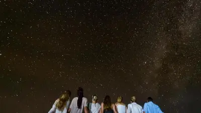 a group of people standing under a starry sky at Bivouac Karim Sahara in Zagora