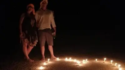 two people standing in front of a circle of candles at Bivouac Karim Sahara in Zagora