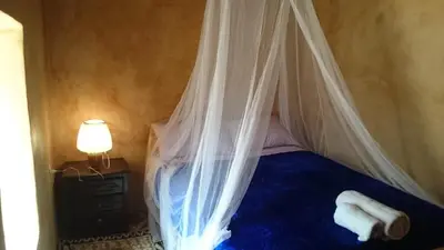 a bedroom with a bed with a mosquito net at Camping Bassou in Nkob