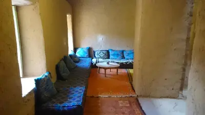a living room with a blue couch and a table at Camping Bassou in Nkob