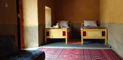 a small room with two beds and a rug at Camping Bassou in Nkob