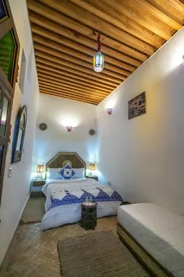 a bedroom with a bed and a wooden ceiling at Dar Mchachti fes in Fès