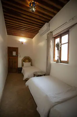 a bedroom with two beds and a window at Dar Mchachti fes in Fès