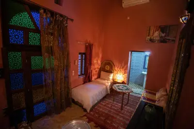 a bedroom with a bed and a window and a door at Dar Mchachti fes in Fès