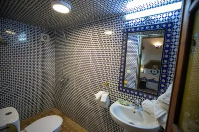 a bathroom with a sink and a toilet and a mirror at Dar Mchachti fes in Fès