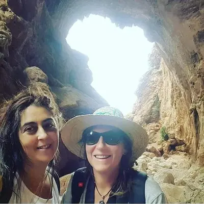 two women standing in front of a cave at Le petit Jardin in Demnat