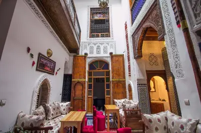 a living room with a table and chairs at DAR MILOUDA RCIF in Fès