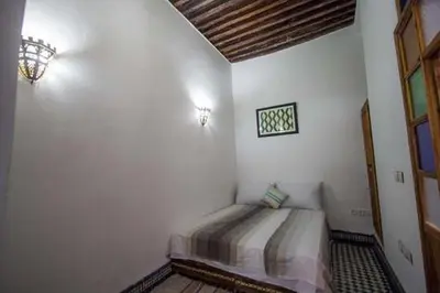a bedroom with a bed in the corner of a room at DAR MILOUDA RCIF in Fès