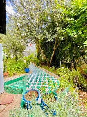 a swimming pool with a green and blue tile floor at Dar Jardin Majorelle Fez in Fès