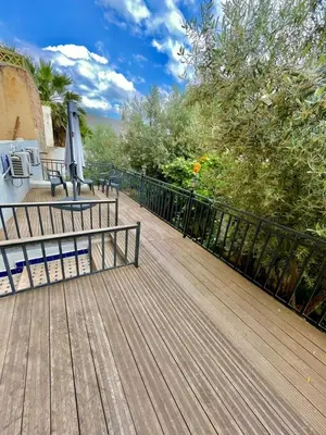 a wooden deck with a black fence and trees at Dar Jardin Majorelle Fez in Fès