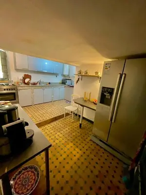 a kitchen with a refrigerator and a table in it at Dar Jardin Majorelle Fez in Fès