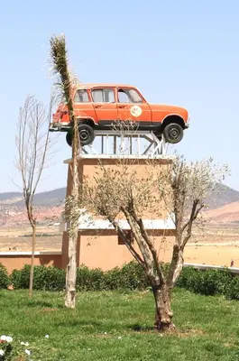 a car on top of a building with a tree at Hotel Meteorites Boulaajoul in Zaida