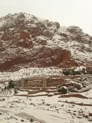 a building in the middle of a snow covered mountain at Auberge Le Festival Todra Gorge in Aït Baha