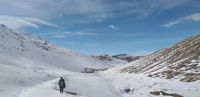a man is walking down a snow covered mountain at Dar Angour Tacheddirt in Tacheddirt