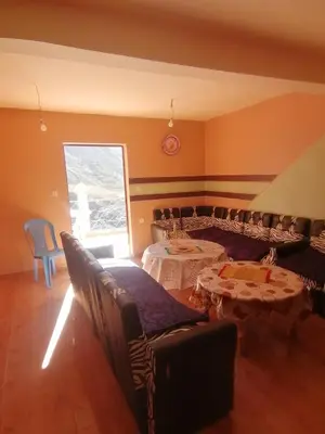 a room with two tables and a couch and a window at Dar Angour Tacheddirt in Tacheddirt