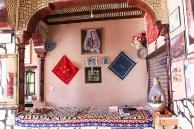 a bedroom with a bed with a picture on the wall at La Rose De Sable in Aït Ben Haddou