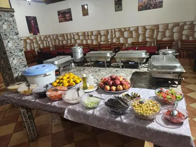 a table with bowls of fruits and vegetables on it at La Rose De Sable in Aït Ben Haddou