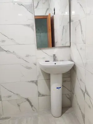 a white bathroom with a sink and a mirror at La Rose De Sable in Aït Ben Haddou