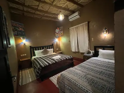 a hotel room with two beds and a window at Kasbah Ait BenHadda in Skoura