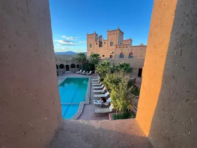 a view of a swimming pool with a castle in the background at Kasbah Ait BenHadda in Skoura
