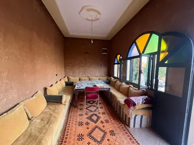 a room with a couch and a table and windows at Kasbah Ait BenHadda in Skoura