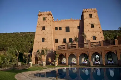 a large building with a pool in front of it at Kasbah Illy in Demnat