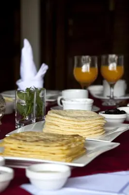 a table with a plate of crackers and glasses of orange juice at Kasbah Illy in Demnat