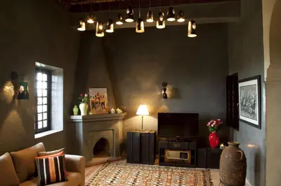 a living room with a fireplace and a television at Kasbah Illy in Demnat