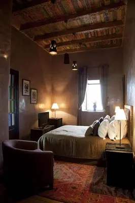 a bedroom with a bed and a window and a couch at Kasbah Illy in Demnat