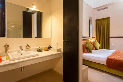 a bathroom with a sink and a bed and a mirror at Hapimag Resort Marrakesh in Douar Soukkane