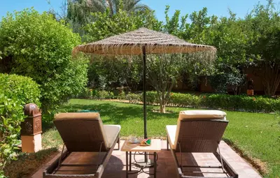 two chairs and a table under an umbrella at Hapimag Resort Marrakesh in Douar Soukkane