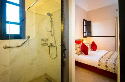 a bathroom with a shower and a bed in a room at Hapimag Resort Marrakesh in Douar Soukkane