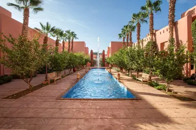 a pool in the middle of a street with palm trees at Hapimag Resort Marrakesh in Douar Soukkane