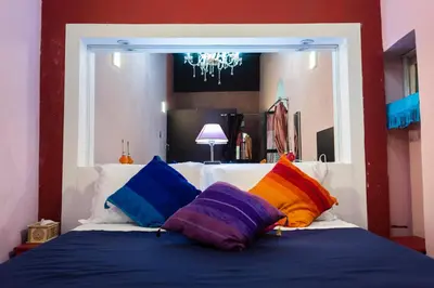a bedroom with a bed with colorful pillows on it at Dar anne in Fès