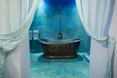 a bathroom with a wooden tub in a blue room at Dar anne in Fès