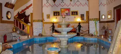 a water fountain in a room with blue tiles at Dar Essyaha in Ait Ben Ali