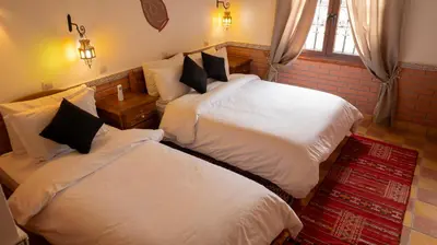 a bedroom with two beds and a window at Dar Essyaha in Ait Ben Ali