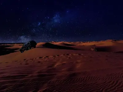 a person laying on top of a desert at night at Camp Sahara Majestic in Mhamid