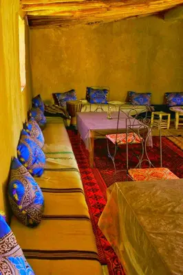 a room with several tables and chairs in a room at Camp Sahara Majestic in Mhamid
