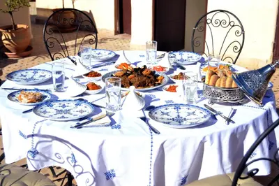 a table with blue and white plates of food on it at Riad Meyssane Fès in Fès