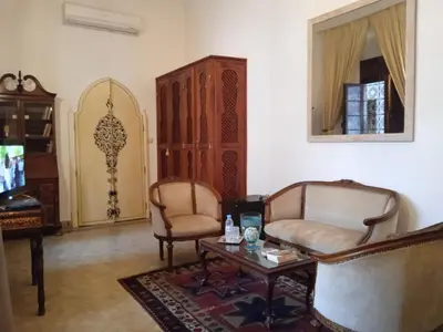 a living room with two chairs and a table and a mirror at Riad Meyssane Fès in Fès