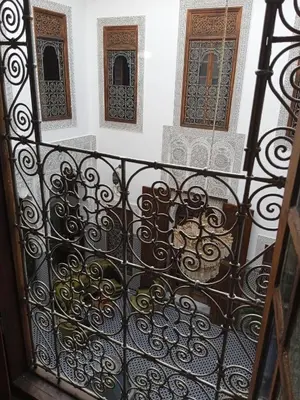 a balcony with a wrought iron fence and three windows at Riad Meyssane Fès in Fès