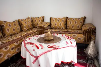 a living room with a table and a couch at Ryad Zahrat Fes in Fès