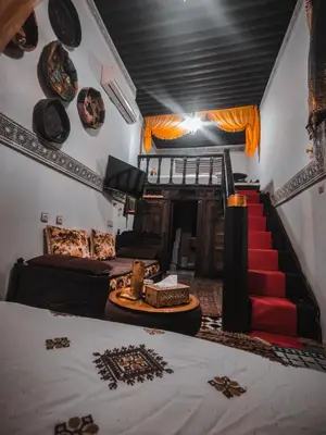a living room with a couch and a stair case at Ryad Zahrat Fes in Fès