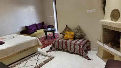 a bedroom with a bed and a couch and a fireplace at Le Chêne d´Azrou in Azrou