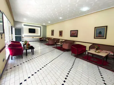 a waiting room with red chairs and tables at Hotel Splendid in Fès