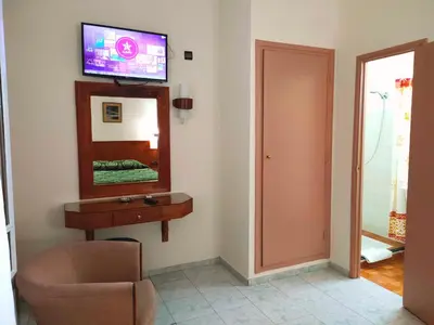 a room with a mirror and a chair and a television at Hotel Splendid in Fès