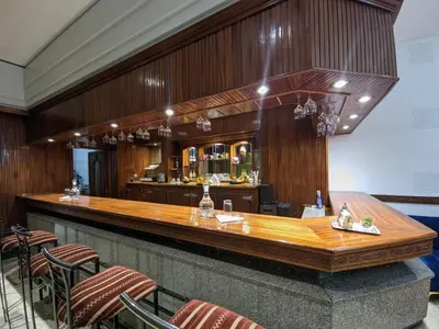 a bar in a restaurant with wooden walls and chairs at Hotel Splendid in Fès