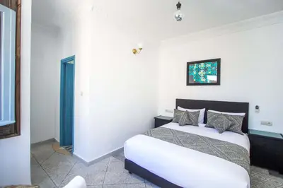 a bedroom with a large white bed with pillows at Cine House in Fès