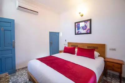 a bedroom with a large bed with red pillows at Cine House in Fès
